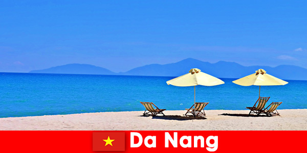 Turistas de pacotes relaxam nas praias azuis de Da Nang, Vietnã