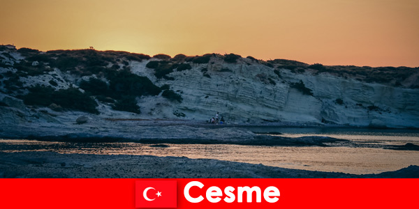 Os turistas adoram longas caminhadas na praia em Cesme Turquia